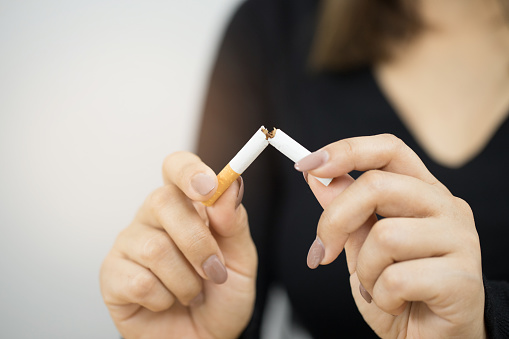 A person breaking a cigarette