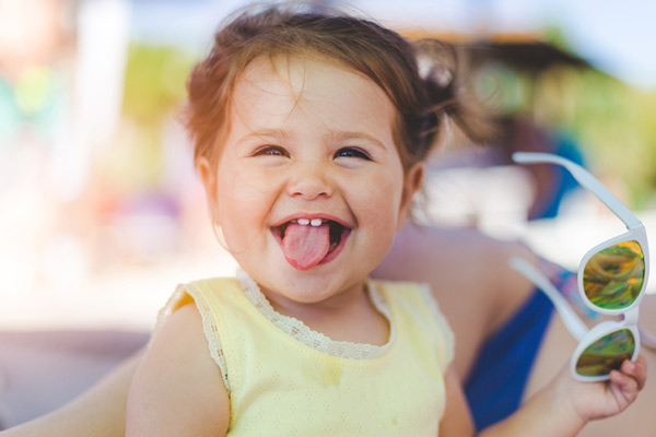 Toddler girl sticking out her tongue and smiling.